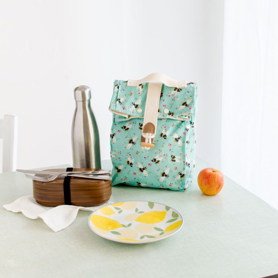 Table composition with a bag on it made of Blue organic cotton poplin with black and yellow bees and colourful flowers